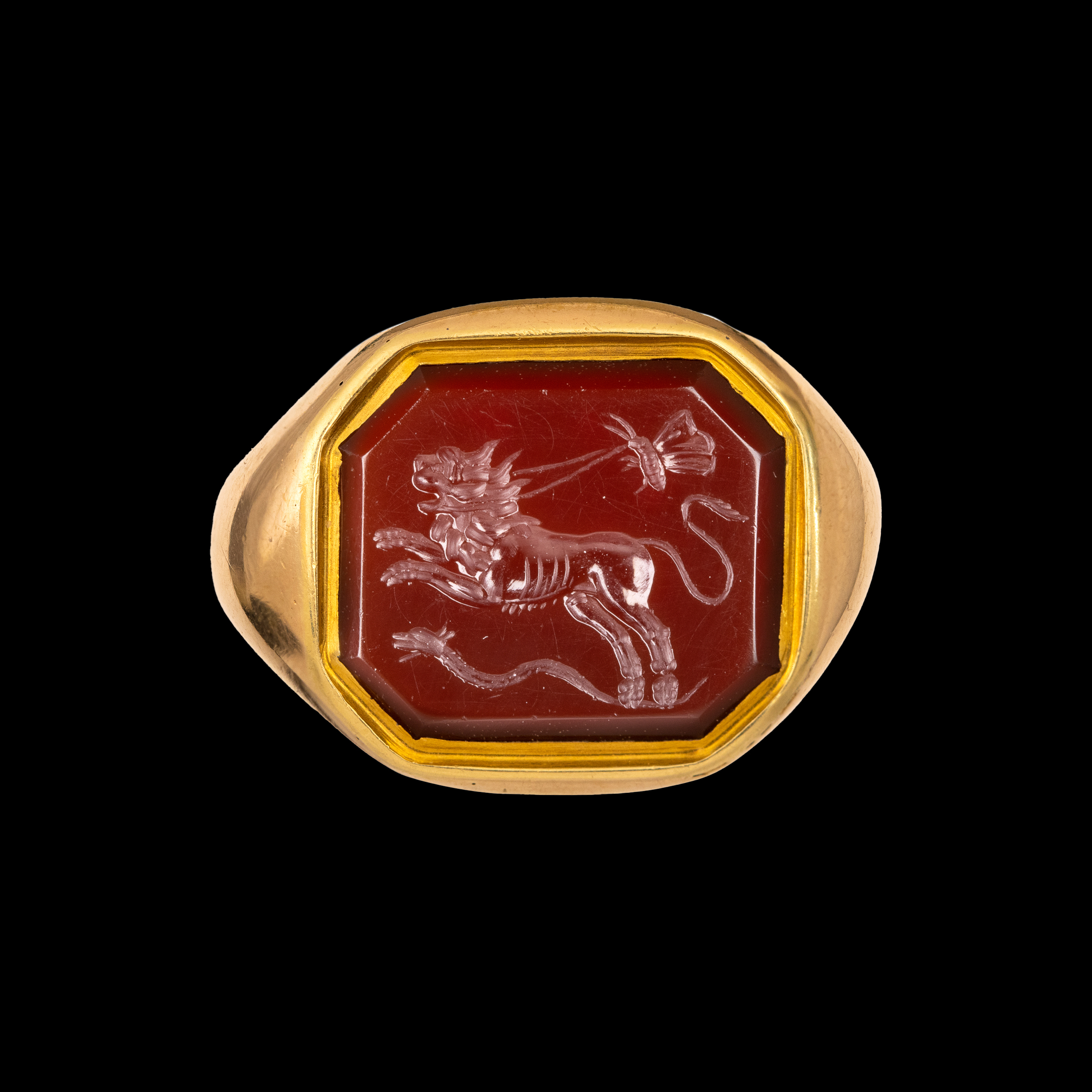 A 19th century gold ring set with a Roman carnelian intaglio. Allegorical scene with lion. 